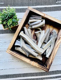 a wooden box with a few pieces of bone in it