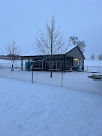 a dog park in the snow with a fence