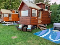 a tiny house is parked in a grassy area